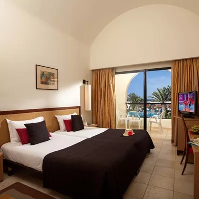 Suite spacieuse sous plafond voûté avec terrasse privée donnant sur les jardins et la mer à Djerba.