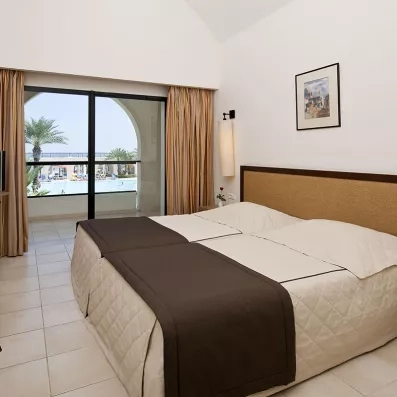 Chambre double lumineuse du Sentido Djerba Beach avec balcon offrant une vue imprenable sur la piscine.