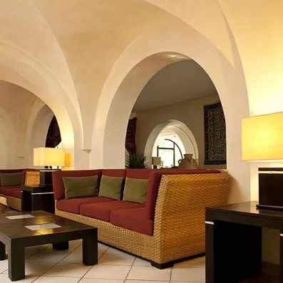 Salon intérieur luxueux sous des voûtes traditionnelles offrant une atmosphère culturelle et apaisante en Tunisie.