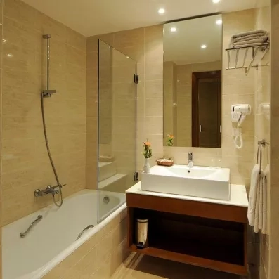 Salle de bain moderne de l'hôtel Djerba Resort équipée d'une baignoire et d'un plan vasque épuré.