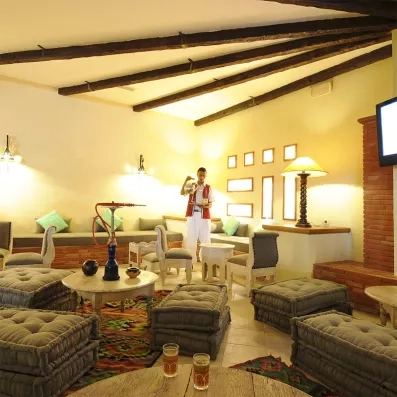 Café maure traditionnel au Djerba Resort avec banquettes, tapis colorés et service de thé à la menthe.