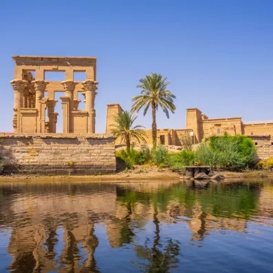 Kiosque de Trajan au temple de Philae se reflétant sur les eaux calmes du Nil, Égypte.