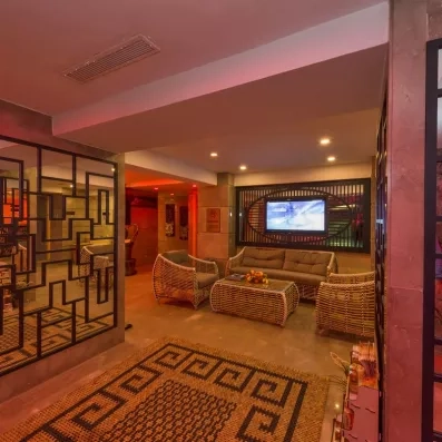 Hall d’entrée avec coin salon équipé de canapés et d’une télévision