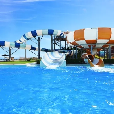 Parc aquatique avec grands toboggans colorés au Jaz Aquamarine Hurghada, vacances fun en famille en Égypte.