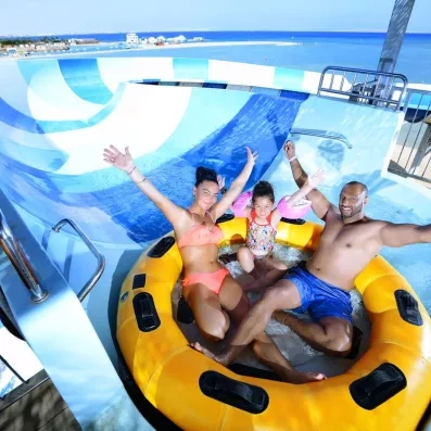 Famille sur une bouée géante au sommet d'un toboggan, vue mer au Jaz Aquamarine Égypte.