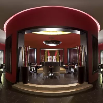 Design oriental moderne restaurant Jaz Aquamarine 5*, architecture circulaire rouge, ambiance tamisée Hurghada Égypte.