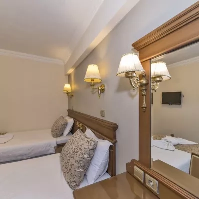 chambre avec deux lits simples et un grand miroir