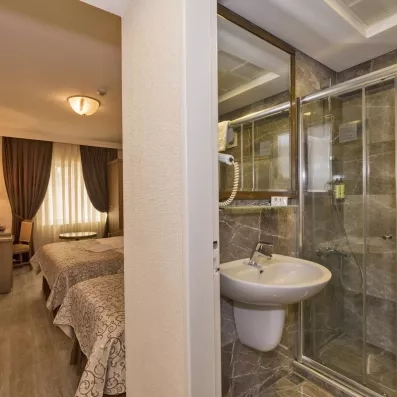 chambre avec deux lits simples et une salle de bai en marbre