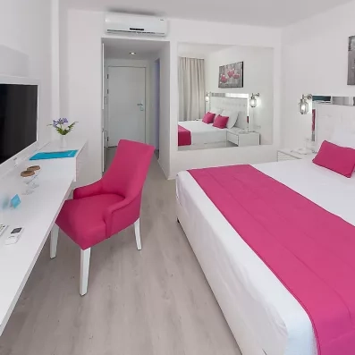 Une chambre moderne et lumineuse, comprenant un bureau et un fauteuil.