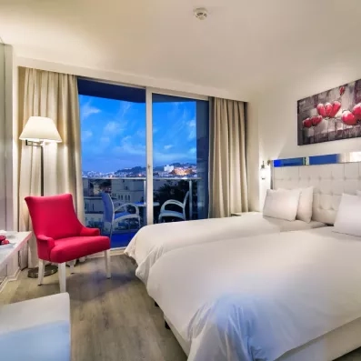 Une chambre à lits jumeaux offrant une belle vue à travers de grandes baies vitrées.