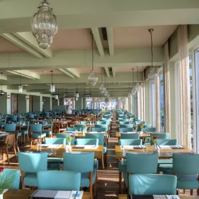 Une vaste salle de restaurant intérieure, baignée de lumière naturelle.