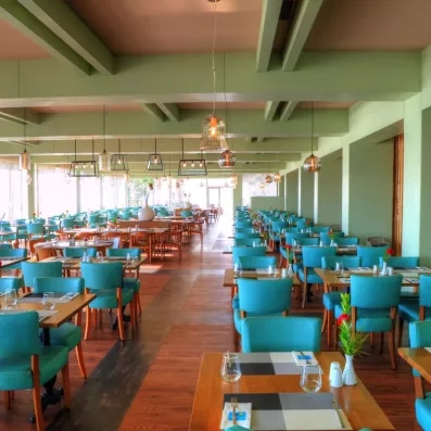 Une salle de restaurant spacieuse et moderne, mêlant mobilier en bois et fauteuils.