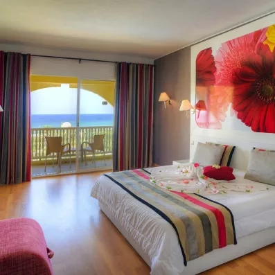 Chambre avec deux lits simples et balcon vue mer au Mondi Club One Resort Jockey à Monastir, Tunisie.