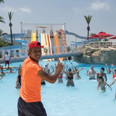 Activités club de vacances au One Resort Jockey Monastir : cours de fitness en piscine et toboggans géants pour un séjour familial en Tunisie.