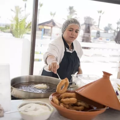 Chef préparant des pâtisseries tunisiennes traditionnelles (fricassés ou beignets) au buffet du Mondi Club One Resort Jockey Monastir.