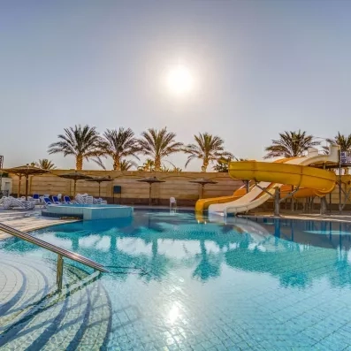 piscine extérieur avec toboggans, transats, parasols, palmiers