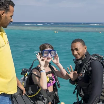 Touristes en équipement de plongée prêts pour une immersion culturelle marine au Mondi Club Stella Garden.