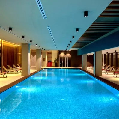 grande piscine intérieure avec des transats