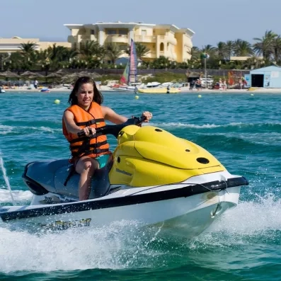 Femme en gilet de sauvetage faisant du jet-ski sur la mer Méditerranée au Royal Thalassa Monastir.