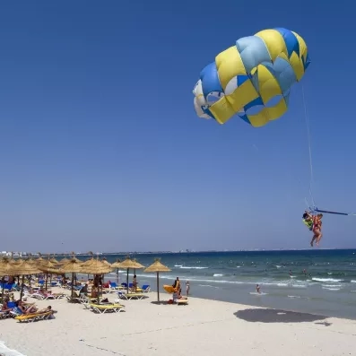 Session de parachute ascensionnel au-dessus de la plage ensoleillée de l’hôtel Royal Thalassa à Monastir.