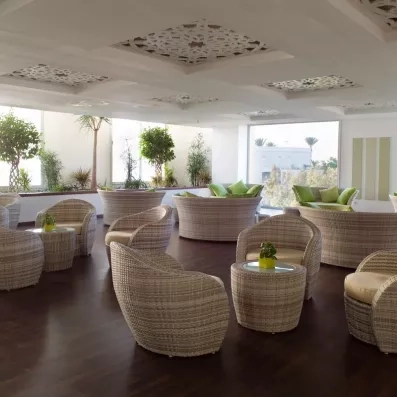Salon de détente élégant avec fauteuils en osier et décoration orientale moderne au Royal Thalassa Monastir.