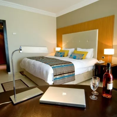 Chambre luxueuse avec bureau, ordinateur et vin rosé pour un séjour confort au Royal Thalassa Monastir.