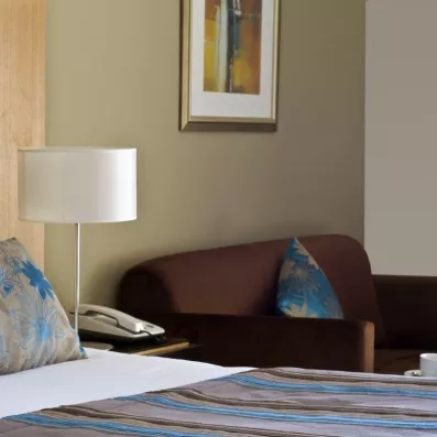 Détail d'une chambre élégante avec lampe de chevet et canapé au complexe hôtelier Royal Thalassa Monastir.