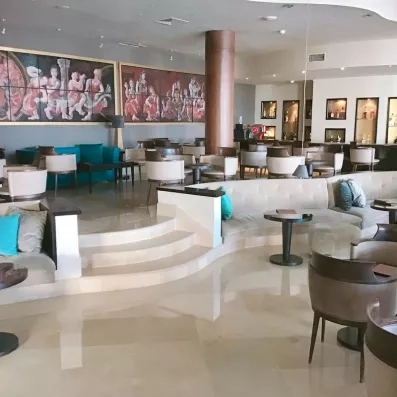 Bar lounge moderne avec fauteuils confortables et fresques artistiques murales au Royal Thalassa Monastir.