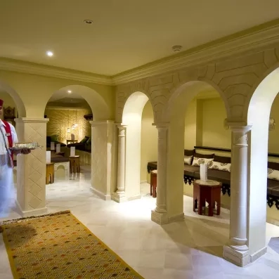 Salon de thé traditionnel aux arches orientales et tapis colorés au Royal Thalassa Monastir, culture tunisienne.