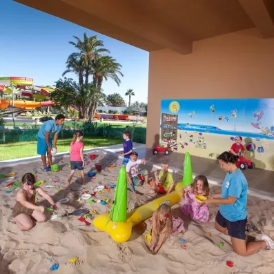 Enfants s'amusant dans l'aire de jeux ensablée du mini-club de l'hôtel Sahara Beach Monastir.