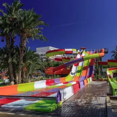 Grands toboggans aquatiques colorés du parc aquatique de l'hôtel Sahara Beach pour des vacances en famille.