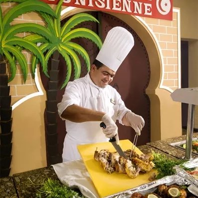 Chef cuisinier préparant des spécialités tunisiennes au buffet du Sahara Beach Resort à Monastir.