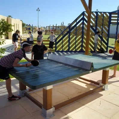 Enfants et adolescents jouant au tennis de table en extérieur au Mondi Club Shems à Monastir.