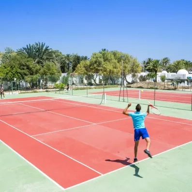 Joueurs de tennis sur un terrain extérieur sous le soleil au Mondi Club Shems à Monastir.