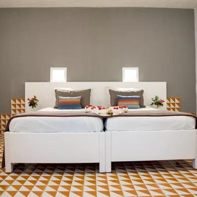 Suite spacieuse avec décoration florale et motifs triangulaires au sol à l'hôtel Mondi Club Shems Monastir.