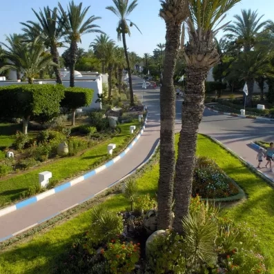 Allées fleuries et jardins paysagers verdoyants traversant le complexe hôtelier Mondi Club Shems à Monastir.