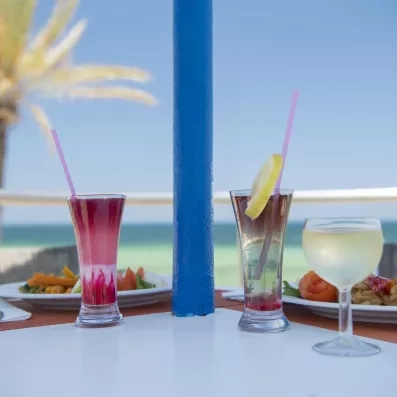 Cocktails rafraîchissants servis en terrasse face à la plage de sable fin de Monastir en Tunisie.
