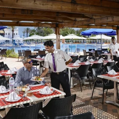 Service à table attentionné sur la terrasse ombragée du restaurant piscine au Mondi Club Shems Monastir.