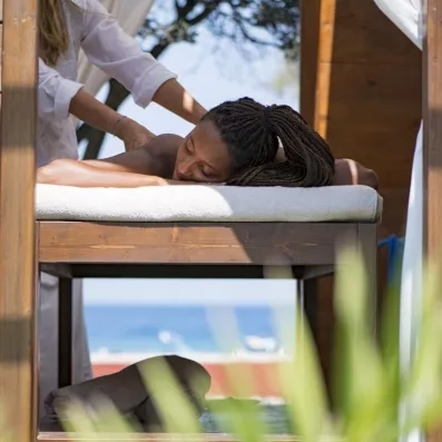 femme se faisant masser sur une table de massage à l'extérieur de l'hôtel 