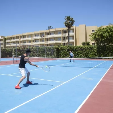 personnes jouant au tennis dans la cour extérieur de l'hôtel
