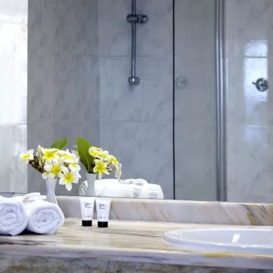 salle de bains avec vasque en marbre, un grand miroir et des serviettes 