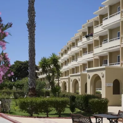 bâtiment de l'hôtel avec les terrasses des chambres et un jardin avec végétation
