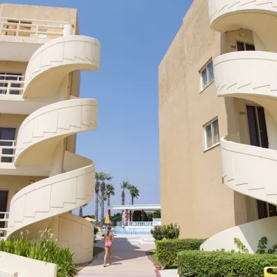 façade hôtel avec escaliers en colimaçon passage vers la piscine