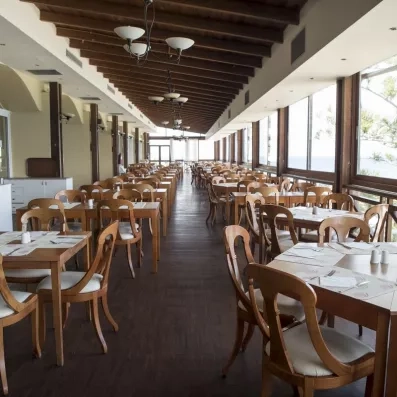 grande salle de restaurant avec des tables et des chaises et des fenêtres en vitre