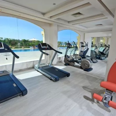 Salle de sport moderne avec tapis de course vue sur mer à l'hôtel Tropitel 5* en Égypte.