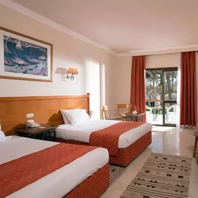 chambre avec 2 lits séparés, tableau décoratif, porte fenêtre menant à la terrasse  