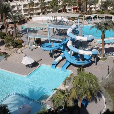 Vue de haut des toboggans aquatiques, des deux grandes piscines, et  de la petite piscine, palmiers 