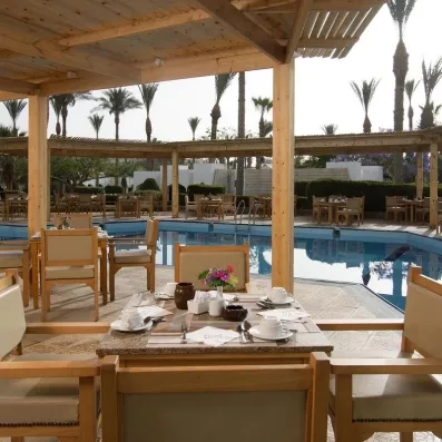 restaurant sur la terrasse avec des tables et des chaises donnants sur la piscine