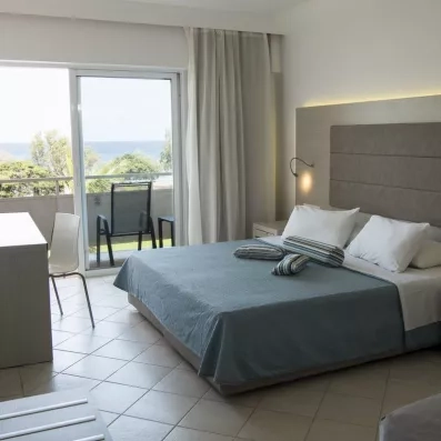 Grand lit chambre double avec grande porte fenêtre, vue sur mer