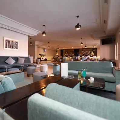 bar de l'hôtel avec canapés bleu et tables basses en bois